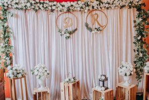 Backdrop pernikahan rustic elegant kain draping putih hoop inisial kayu bunga putih kotak kayu