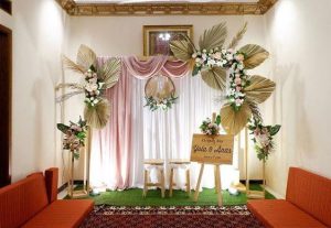 Backdrop dekorasi akad nikah rustic pink gold kain draping daun palem bunga papan nama pengantin
